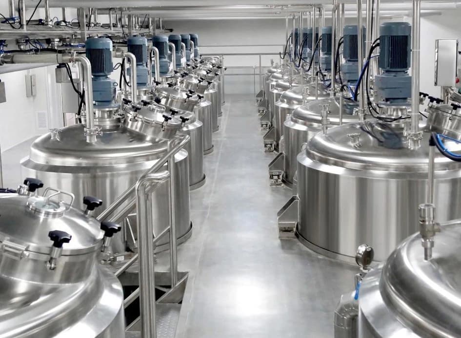 Instalasi fasilitas produksi massal meliputi deretan mixing tank stainless steel lengkap dengan motor agitator dan sistem perpipaan higienis